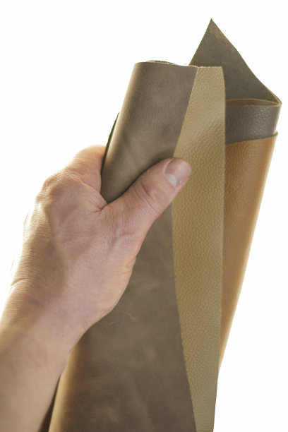 皮革件设置在男性手中的白色背景。棕色皮革背景。图片下载