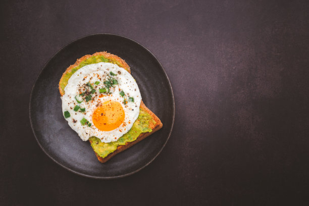 吐司配牛油果和鸡蛋，放在盘子里。图片下载