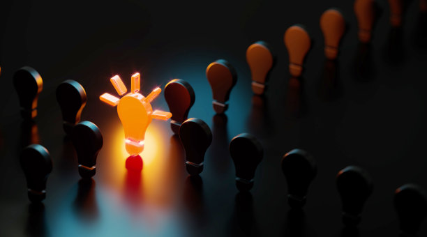 黄色灯泡在黑色背景上的黑色灯泡中发光图片下载