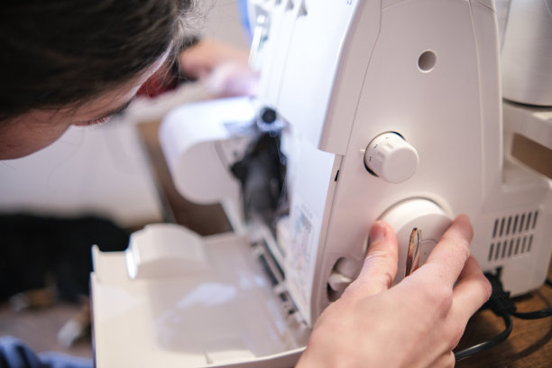 时装设计师正在用缝纫机修补布料图片下载