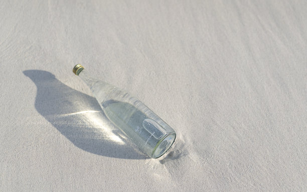 在马尔代夫海滩的白色沙滩上，用玻璃瓶装着纯净水图片下载