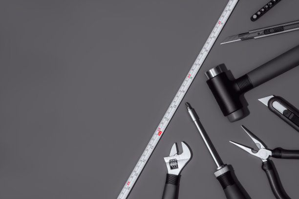 平铺构图与一套家庭维修工具在深灰色的背景。图片下载