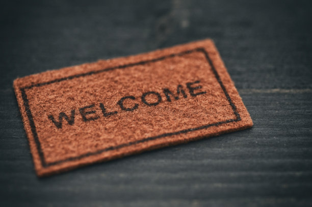 旧的欢迎门垫黑色木制背景图片下载