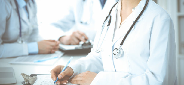 一群不知名的医生坐在诊所开会时讨论阻止冠状病毒大流行的问题，特写。医学的概念图片下载