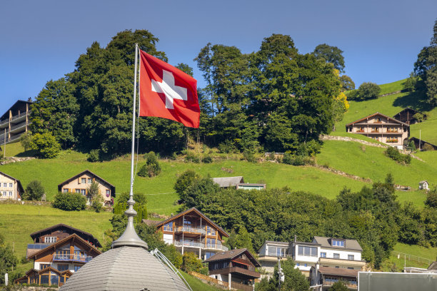 瑞士奥瓦尔登州，阿尔卑斯山脉上的阿尔卑斯恩格尔堡村，挂着瑞士国旗图片下载