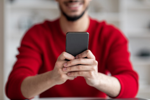 阿拉伯男子坐在桌旁使用智能手机特写图片下载