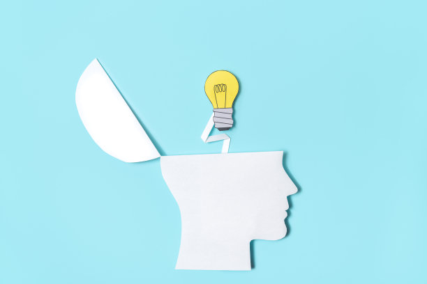 一张从纸上剪下来的人头特写，在浅蓝色的背景上，一个灯泡突然冒出来，作为一个构思创意的概念图像。图片下载