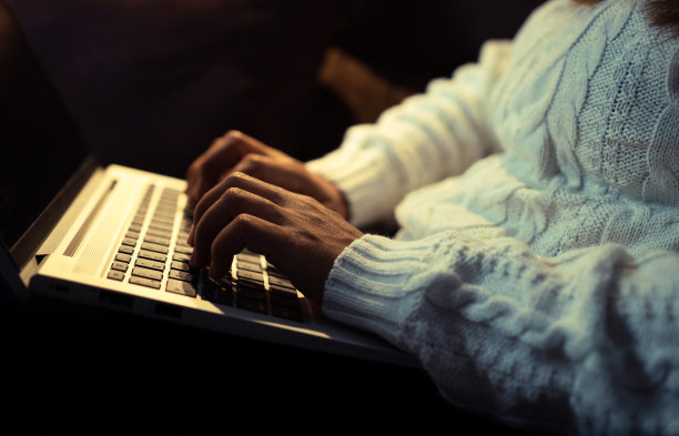 温暖的灯光照亮女性在笔记本电脑上的手指在一个家庭的气氛图片下载