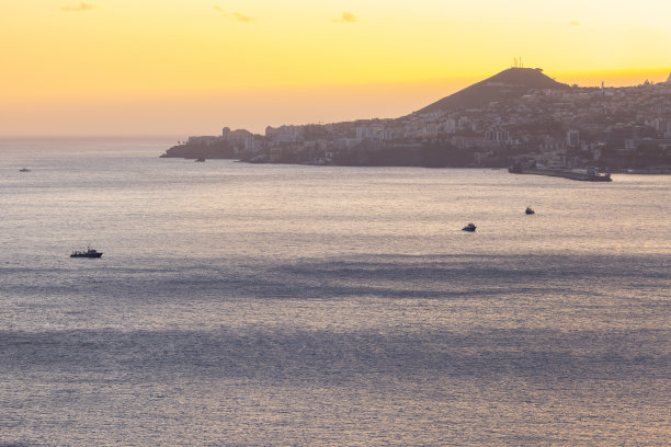 伟大的无人机在美丽的春天日落的海面上拍摄，前景中有一些船。图片下载