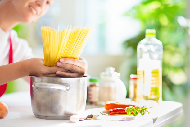 女人在做饭。煮意大利面图片下载
