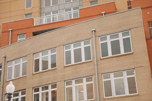 多层砖砌建筑，混合了商业办公室和住宅公寓，具有经典的建筑细节和大窗户。图片下载
