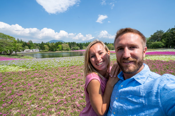 情侣们在日本旅行，与美丽的风景和富士山自拍图片下载