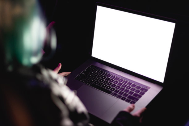 在车里使用笔记本电脑的女性肖像。霓虹灯概念摄影，未来的照片与彩色室内照明的车辆。女孩是司机，人与科技为沟通。概念摄影与空屏幕为模板图片下载