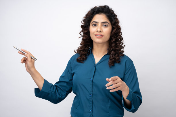 美丽的年轻女商人的肖像指向在白色背景的股票照片的copyspace图片下载