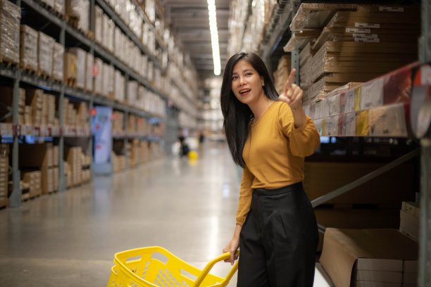 亚洲女购物者在仓库的货架上挑选产品。顾客在百货商店购物的生活方式图片下载