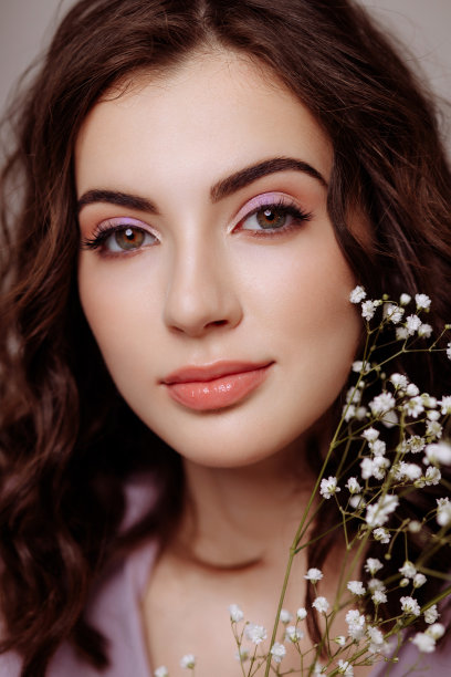 一个黑发女孩手里拿着一束吉卜草花。图片下载