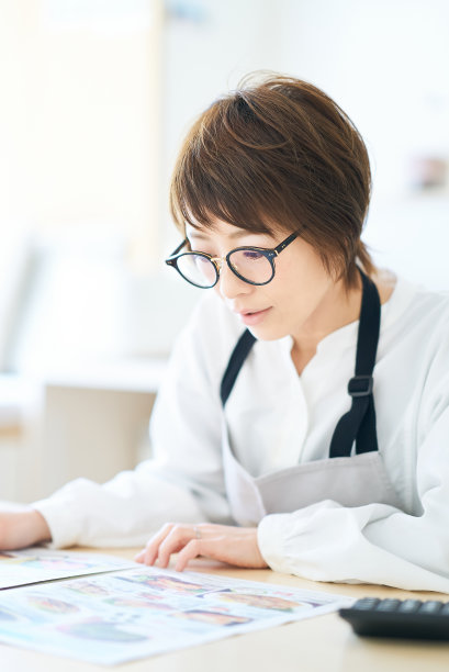 一个戴眼镜的女人正在看广告传单图片下载