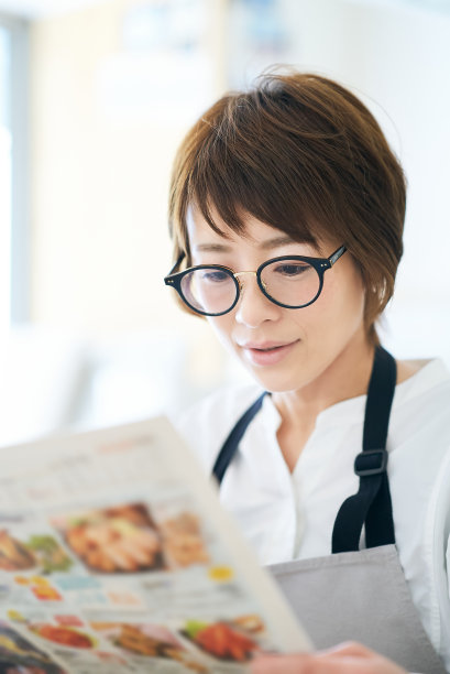 一个戴眼镜的女人正在看广告传单图片下载