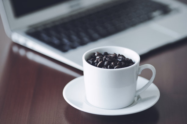 笔记本电脑和白色陶瓷咖啡杯图片下载