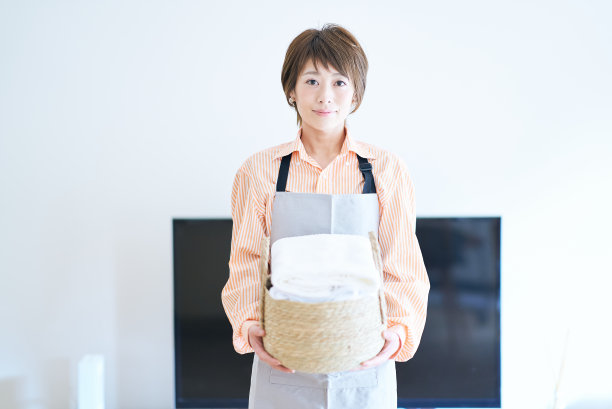 一个围着围裙，拿着衣服的女人图片下载