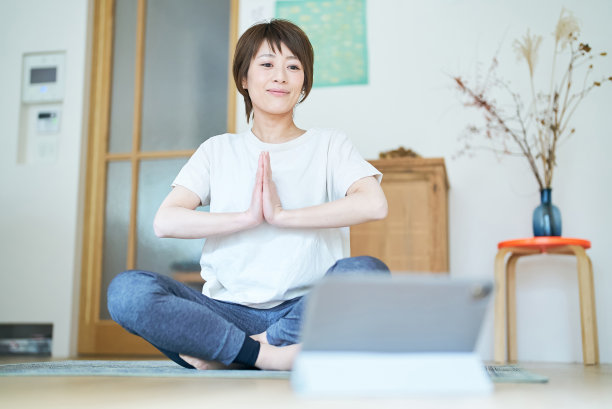 一名女子在看平板电脑屏幕时伸展身体图片下载