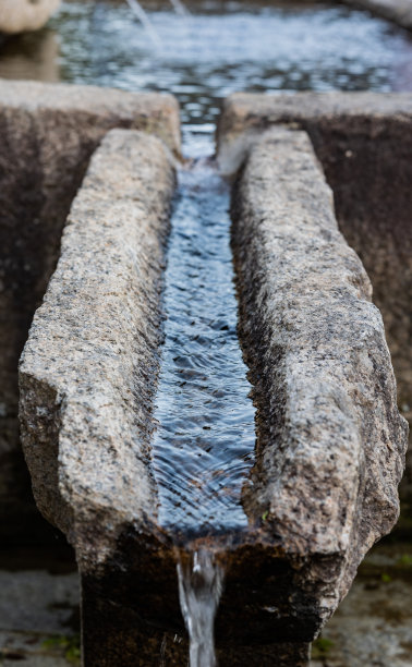 从韩国寺庙里的韩国传统石矿泉流下来的天然清凉的蓝色矿泉水。图片下载