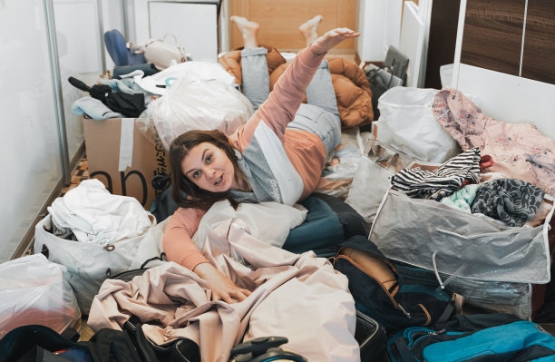 家庭旅行准备困难。搬家，打包，拆包很多东西，衣服，手提箱，行李在家里的公寓。很多包、bags.Mess障碍。聚在一起度假旅行图片下载