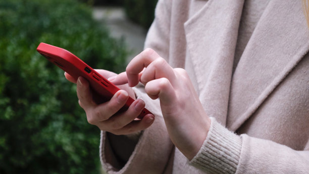 一个女人用手指轻敲她的手机，在互联网上阅读社交媒体，在网上打字或购物。图片下载