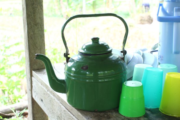 古老的水壶放在古老的木头上。这个旧茶壶是绿色的图片下载