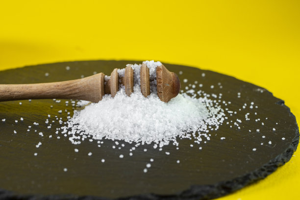 蜂蜜滴在一堆糖晶里，放在一块黑色的石瓦上图片下载