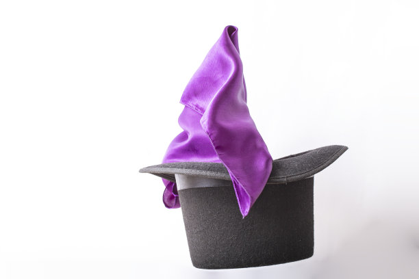 从一顶高帽子里伸出丝质织物，悬浮在白色之上图片下载