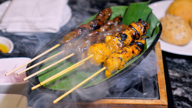 烤鸡肉沙嗲串在香蕉叶上，配上洋葱和酱汁图片下载