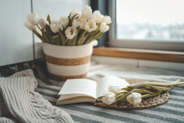 打开书，蜡烛和郁金香篮子，在家里的室内春天的舒适组成图片下载