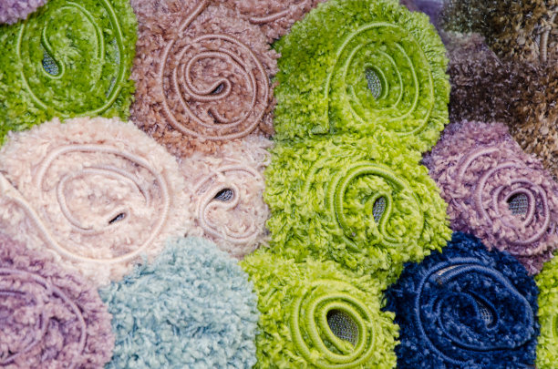 不同的地毯卷在商店的柜台上。各种羊毛地毯，特写图片下载