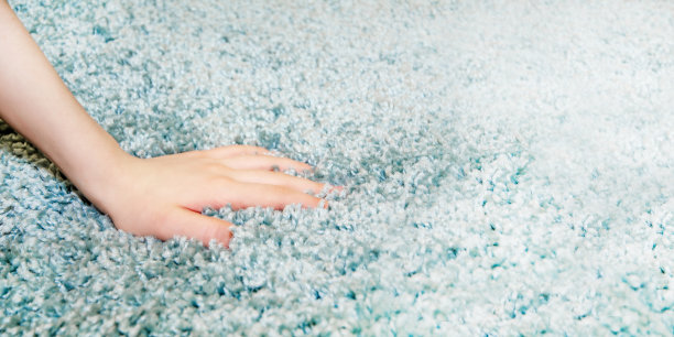 女人选择地毯。手触摸商店里柔软的地毯，特写图片下载