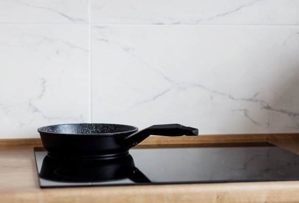 现代黑色电磁炉上的平底锅，图片下载