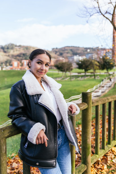 美丽的白人女孩在城市景观公园与令人惊叹的夕阳在垂直人像照片休闲装图片下载