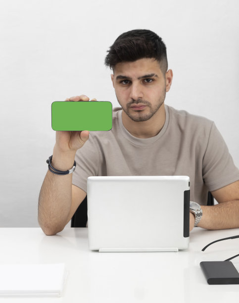 年轻男子在家庭办公室使用智能手机。(带复印空间)教育、商业、电子商务图片下载