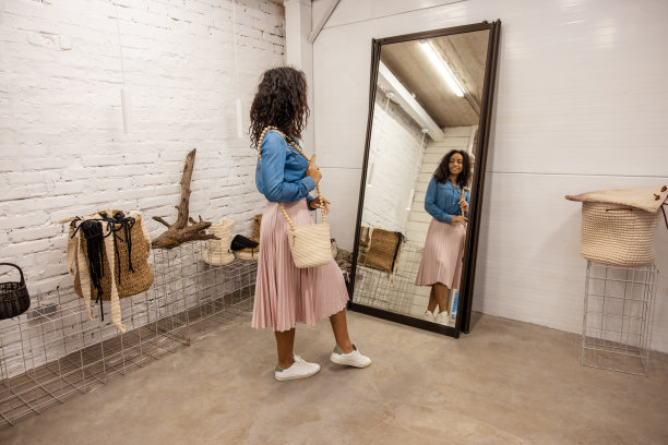 可爱的年轻女子穿着波西米亚风格，在镜子附近摆姿势图片下载