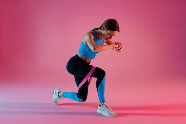 运动的女人站在演播室背景上伸展腿的松紧带图片下载