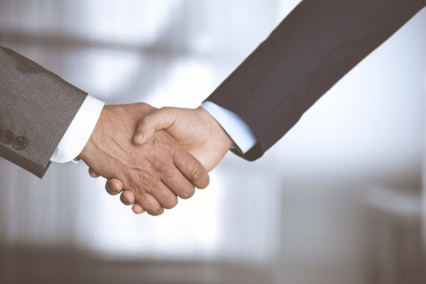 商务人士在签署合同后握手，特写。商务沟通理念。握手与营销图片下载
