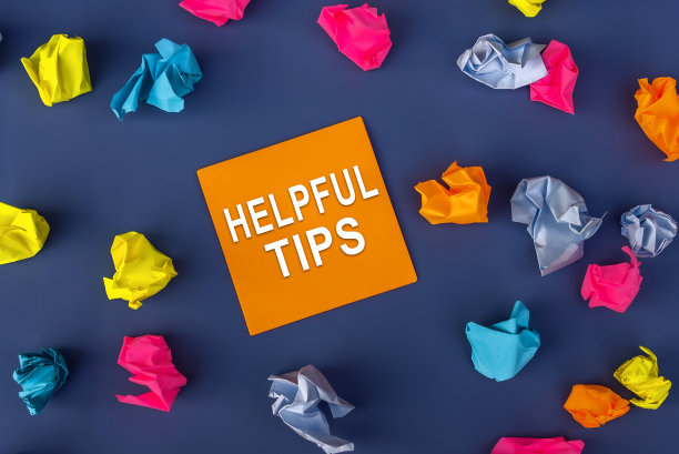 有用的提示-题词的橙色纸笔记旁边的许多彩色皱褶纸球围绕它在紫色的背景。业务，技巧和技巧的概念图片下载