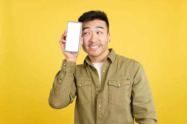 酷酷的中国男人拿着一个空白屏幕的手机图片下载