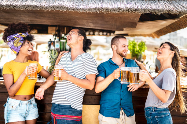 多元文化的潮流朋友有乐趣的祝酒熊在花哨的海滩派对-食品饮料的生活方式概念与年轻的千禧一代在凉爽的chiringuito在欢乐时光-温暖明亮的过滤器图片下载
