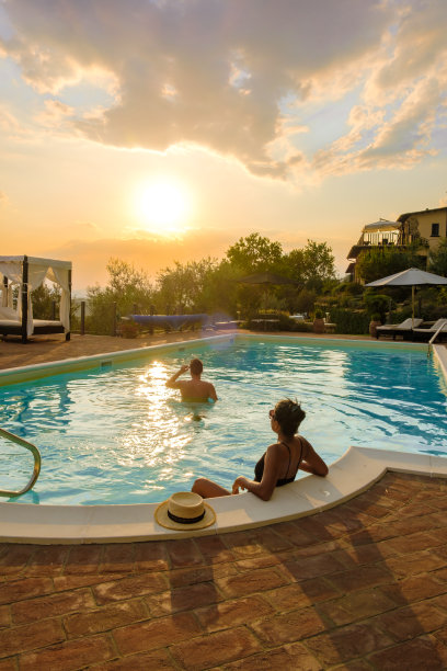 意大利的豪华乡村别墅游泳池。夕阳下的池塘和老农舍图片下载