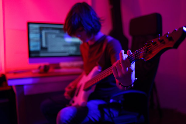 在他的工作室里演奏的贝斯手——特殊灯光效果图片下载