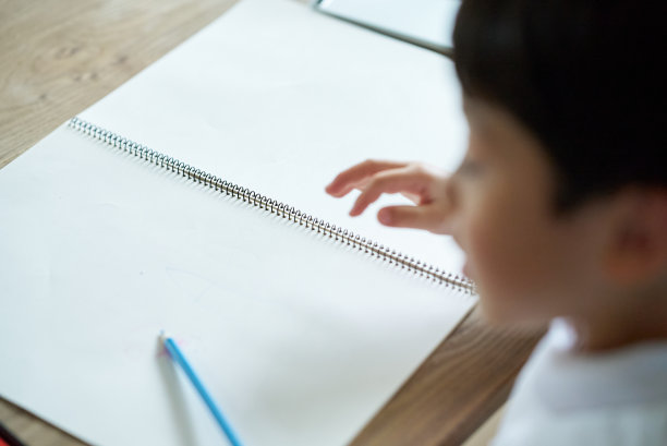 孩子在白色的画纸上画画图片下载