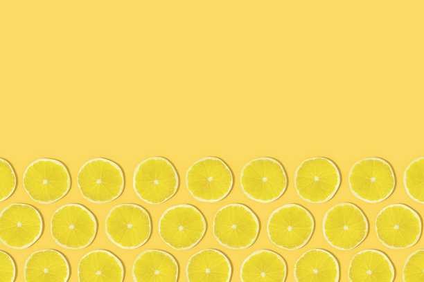 黄色的青柠片，阳光在黄色的背景上图片下载
