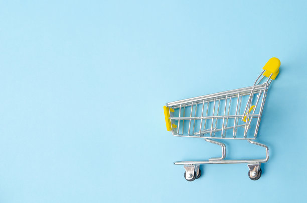 蓝色背景上的空黄色购物车。最小平面布局概念。图片下载