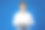 一个开朗英俊的年轻人站在蓝色背景显示空白屏幕笔记本电脑的肖像图片下载